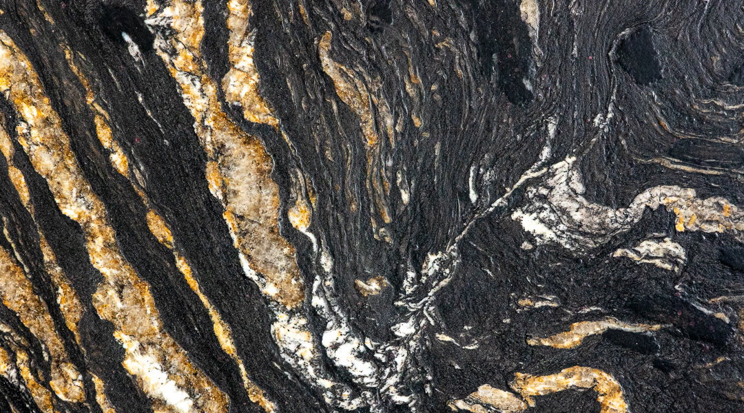 Image of the unique granite, Titanium. It is Jet black with a leather-like texture and cream and goldish veining.