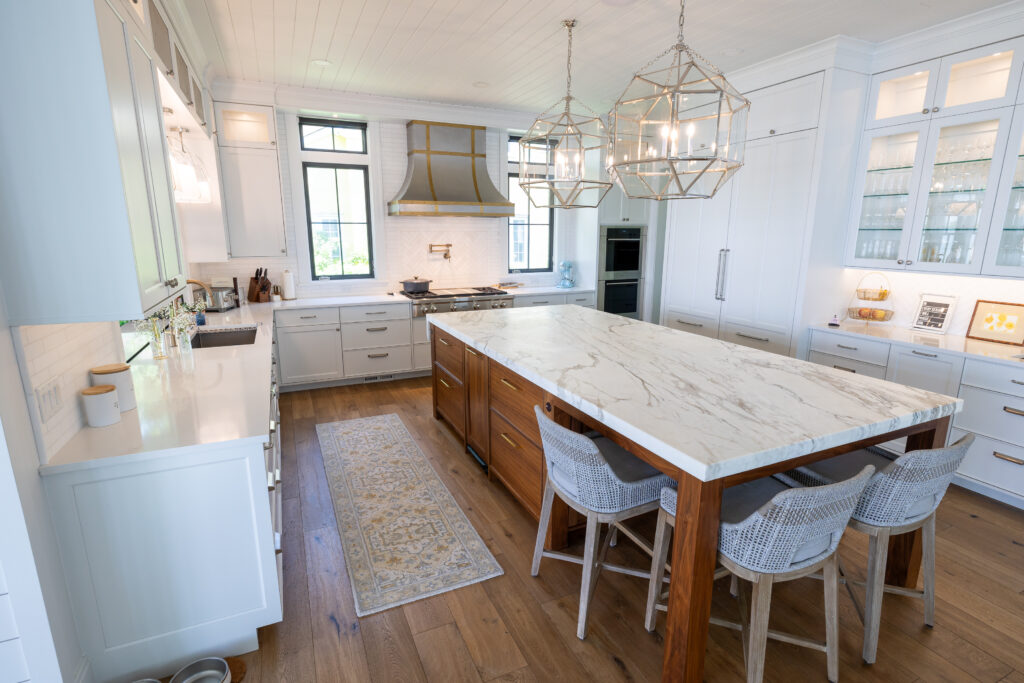 Immaculate kitchen with marble island in center and stone countertops