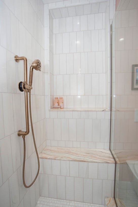 Large tub with natural stone statement wall behind