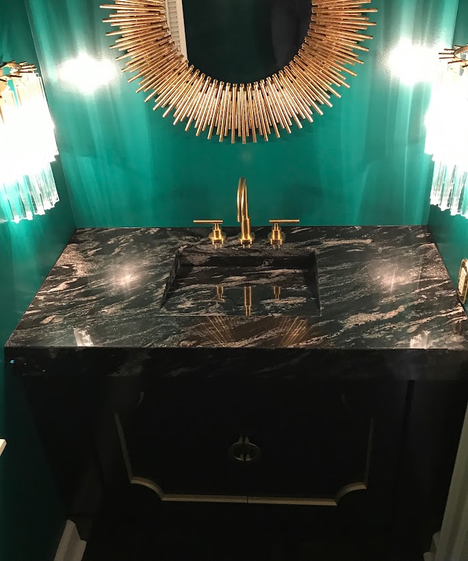 Green bathroom with dark natural stone vanity